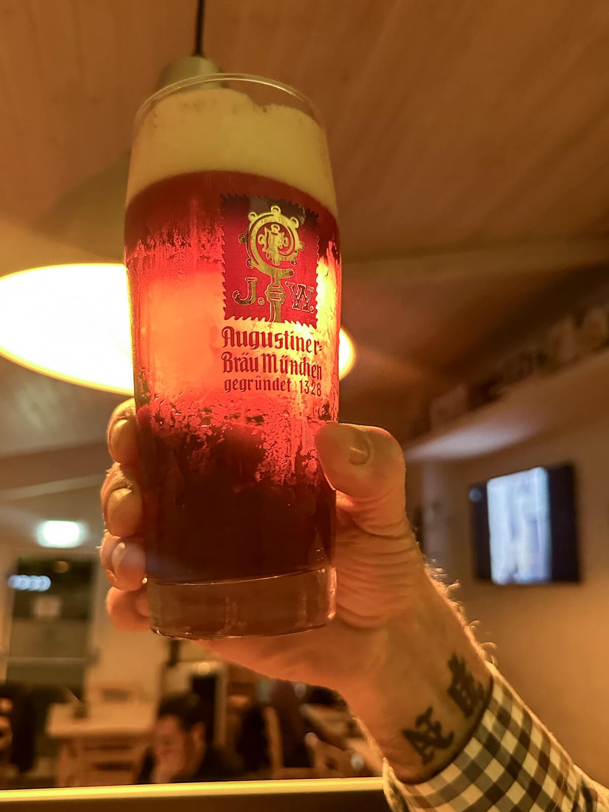 Birra rossa in un boccale tenuta in mano