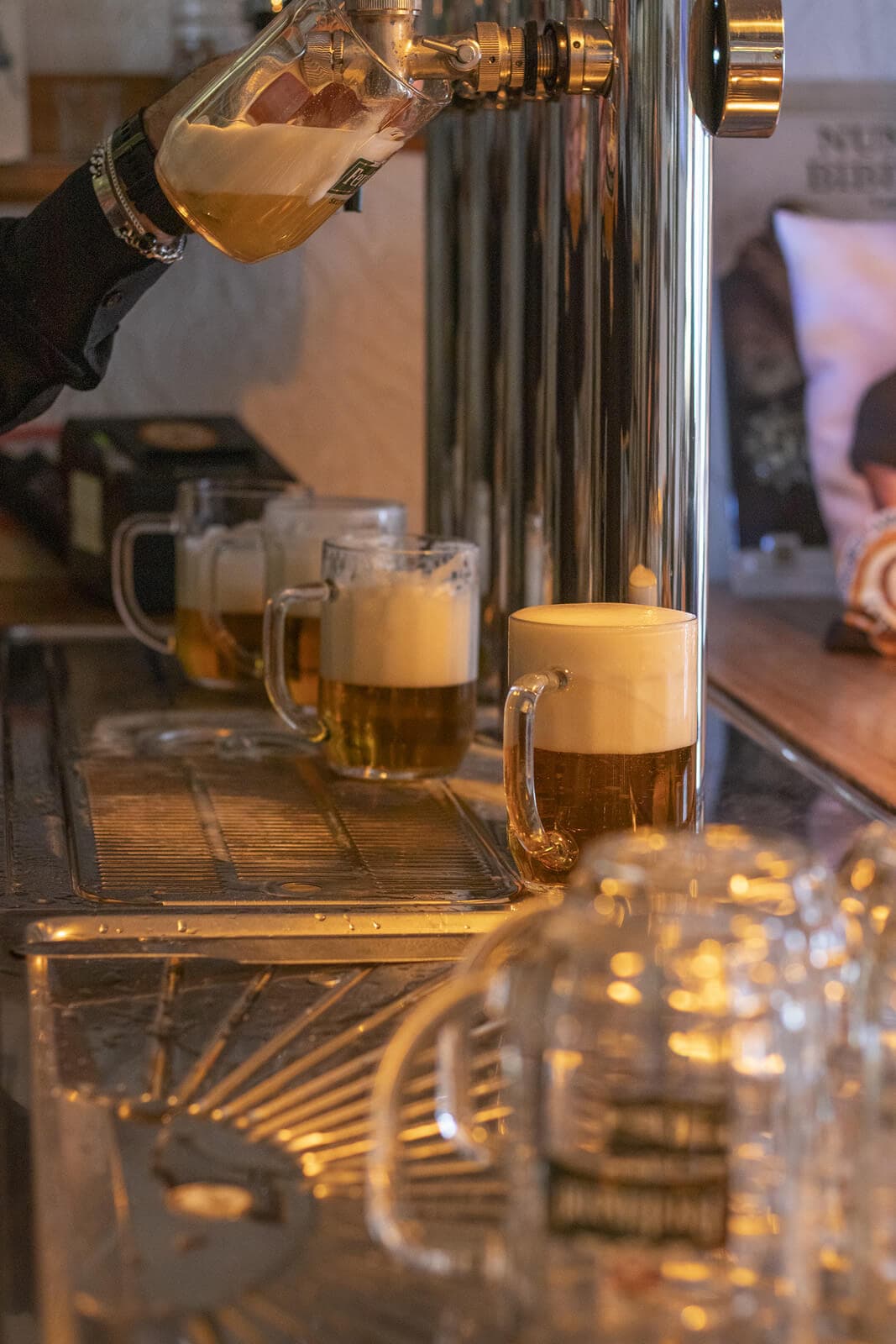 Boccali di birra durante la fase di riempimento