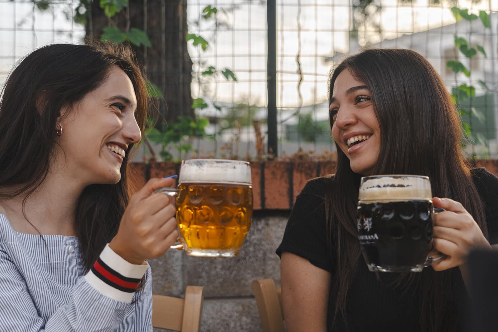 Due ragazze ridono mentre bevono della birra artigianale