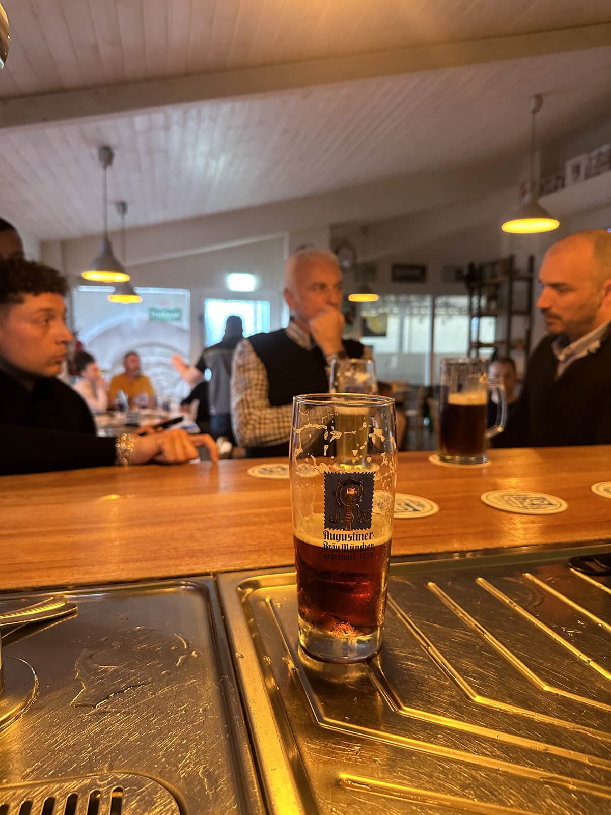 Persone dialogano davanti ad un bicchiere di birra
